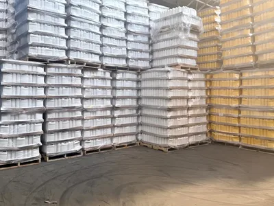 Wrapped pallets of white and yellow one-gallon containers