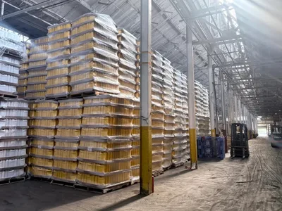 Pallets of packaged containers stacked high under the plant windows