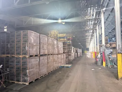 A long warehouse aisle stacked with palletized product
